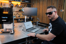 Technician operating Xlaserlab laser marking machine to engrave metal plates