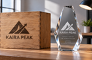 Wooden presentation box and clear faceted award featuring matching Kaira Peak logos, with fine lettering on the award