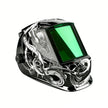 Black welding helmet with green visor and white dragon design, suitable for metalwork safety